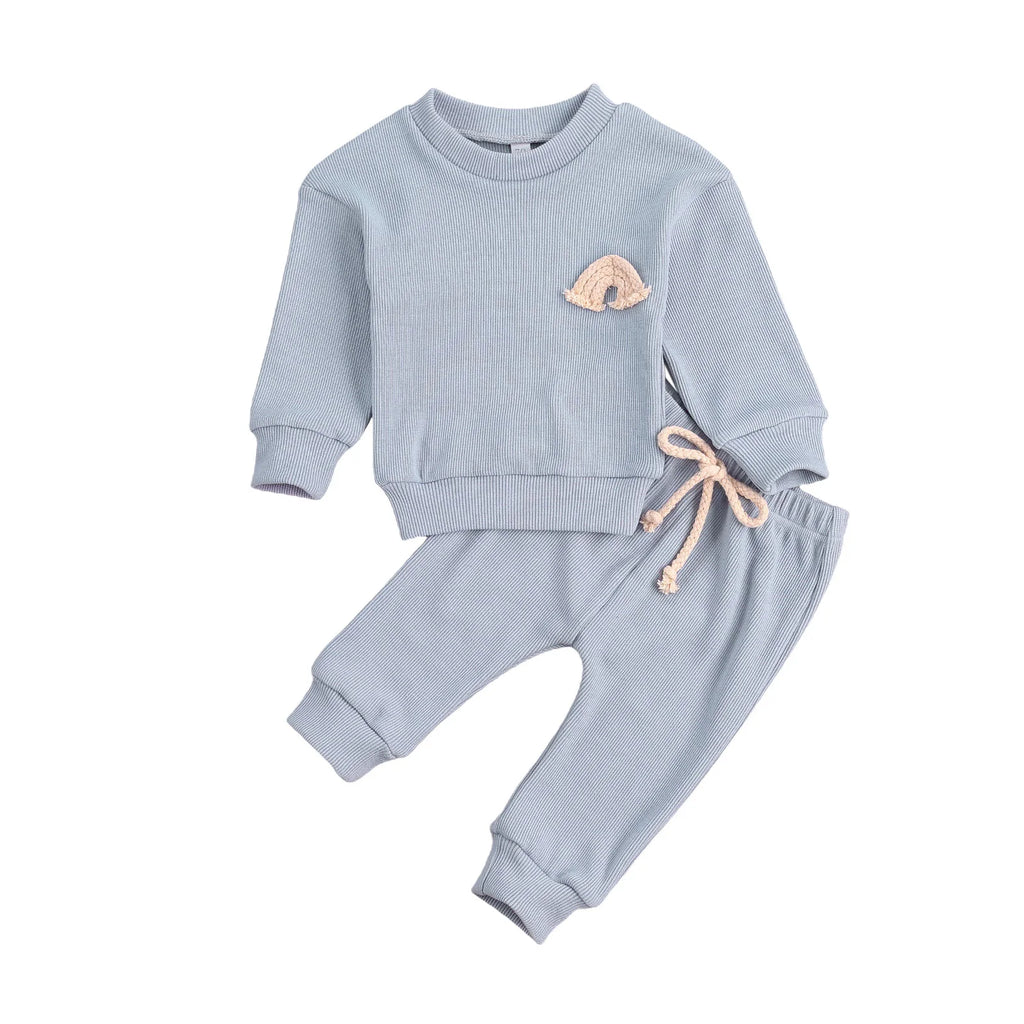 Rainbow embroidered baby top laid flat with matching trousers